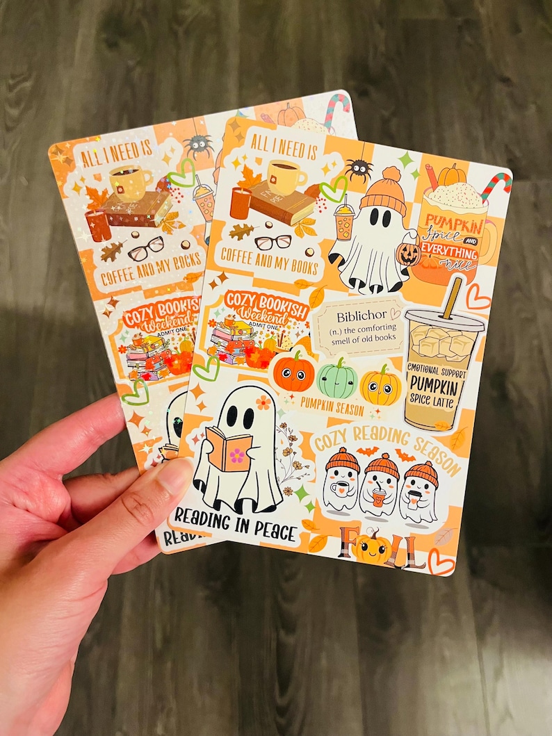 May include: Two rectangular stickers with an orange background and fall-themed illustrations. One sticker features a ghost reading a book, and the other has a coffee cup and the text "Pumpkin Spice and Everything Fall."