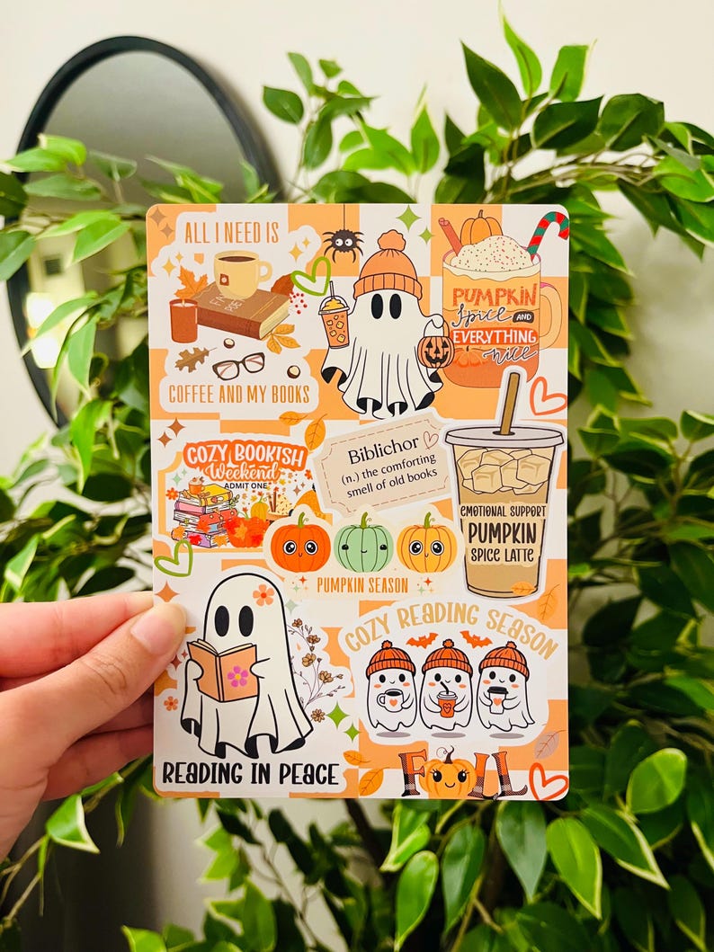 May include: A rectangular sticker sheet with a fall theme. The design features ghost illustrations, pumpkins, coffee cups, and text like "Pumpkin Spice" and "Cozy Reading Season." The background has an orange and white checkered pattern.
