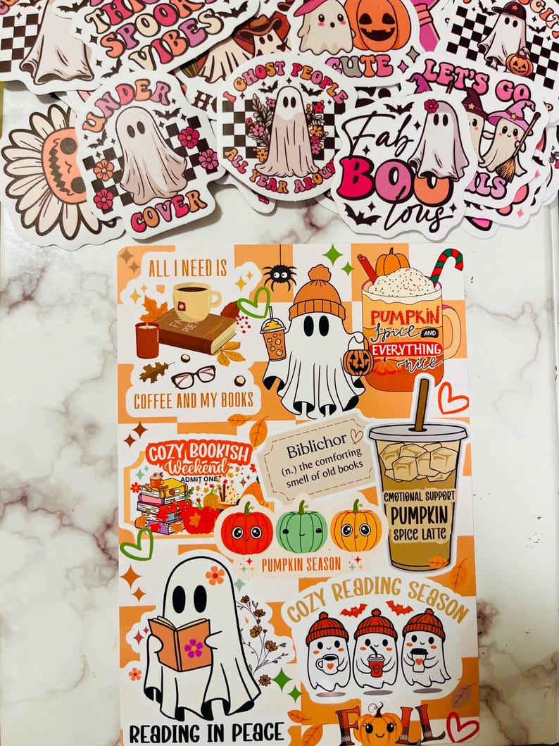 May include: A collection of Halloween-themed stickers and a decorative sheet. The stickers feature ghosts, pumpkins, and phrases like "Spooky Vibes" and "Fab BOO Lous." The sheet includes ghost illustrations, pumpkins, and text such as "Pumpkin Spice Latte."