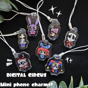May include: A collection of clear acrylic mini phone charms featuring colorful cartoon characters. Each charm has a unique design, including a purple bunny, a sad clown, and a girl with red hair. The charms are attached to white cords.
