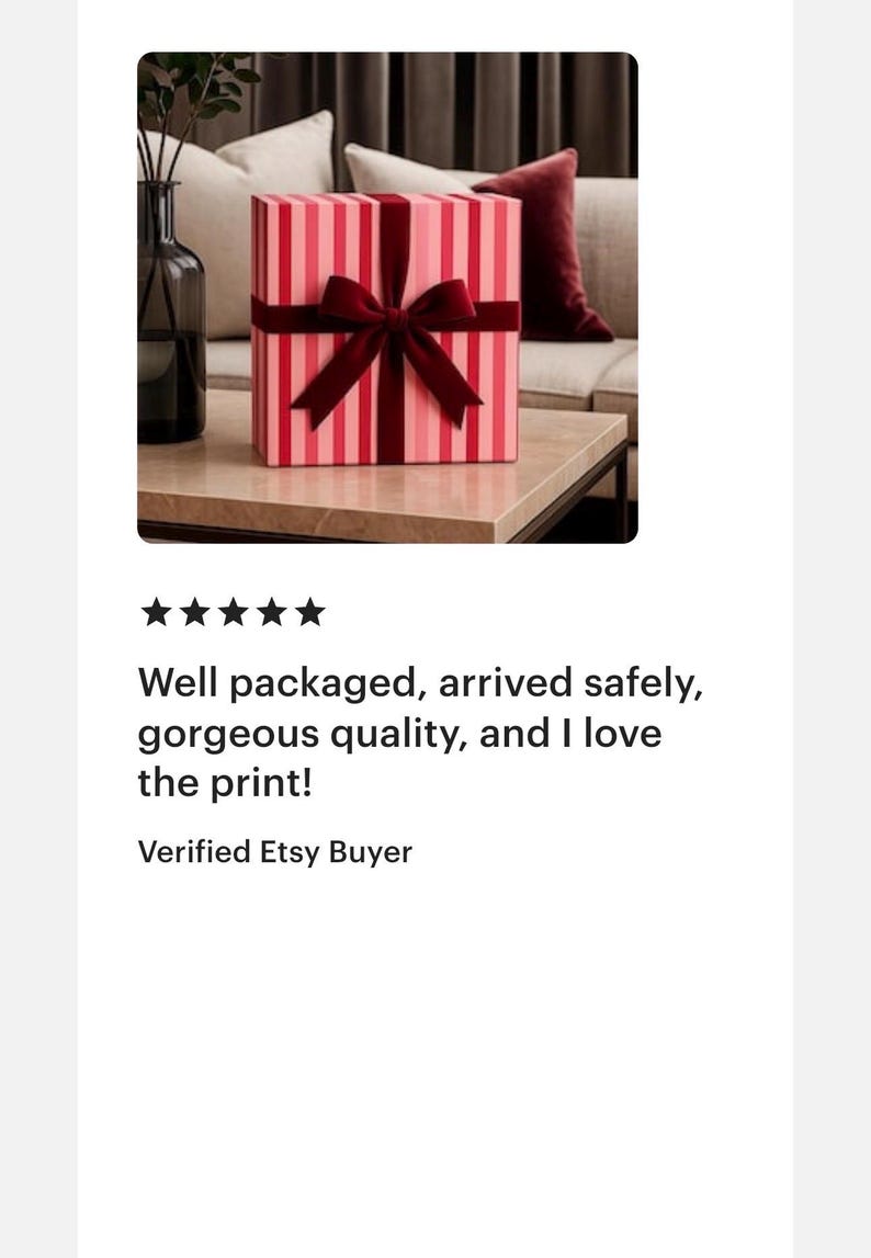 May include: A square gift box featuring a vertical striped pattern in alternating shades of light and dark pink. The box is wrapped with a dark red velvet ribbon tied into a centred bow on the front face, creating a decorative presentation.