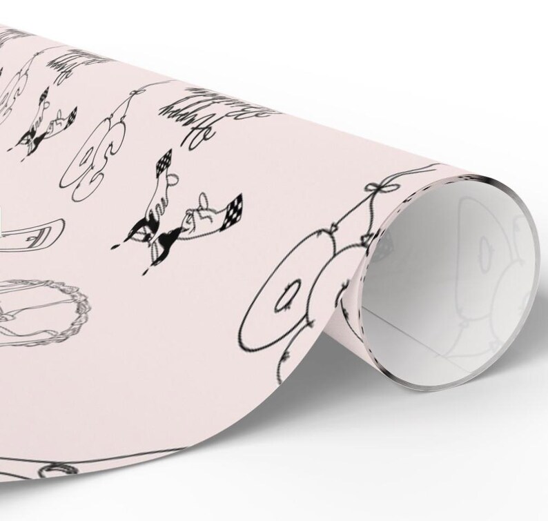 K&ouml;nnte beinhalten: Eine Rolle hellrosa Geschenkpapier mit einem sich wiederholenden schwarzen Strichzeichnungsmuster aus Luftballons, Partyh&uuml;ten und dem Text "Be Happy". Das Papier ist in einer zylindrischen Rollenform dargestellt und zeigt das Design.