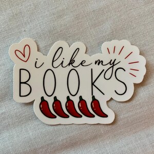 May include: White sticker with black text that reads "I like my BOOKS" with a red heart and red chili peppers below the text.