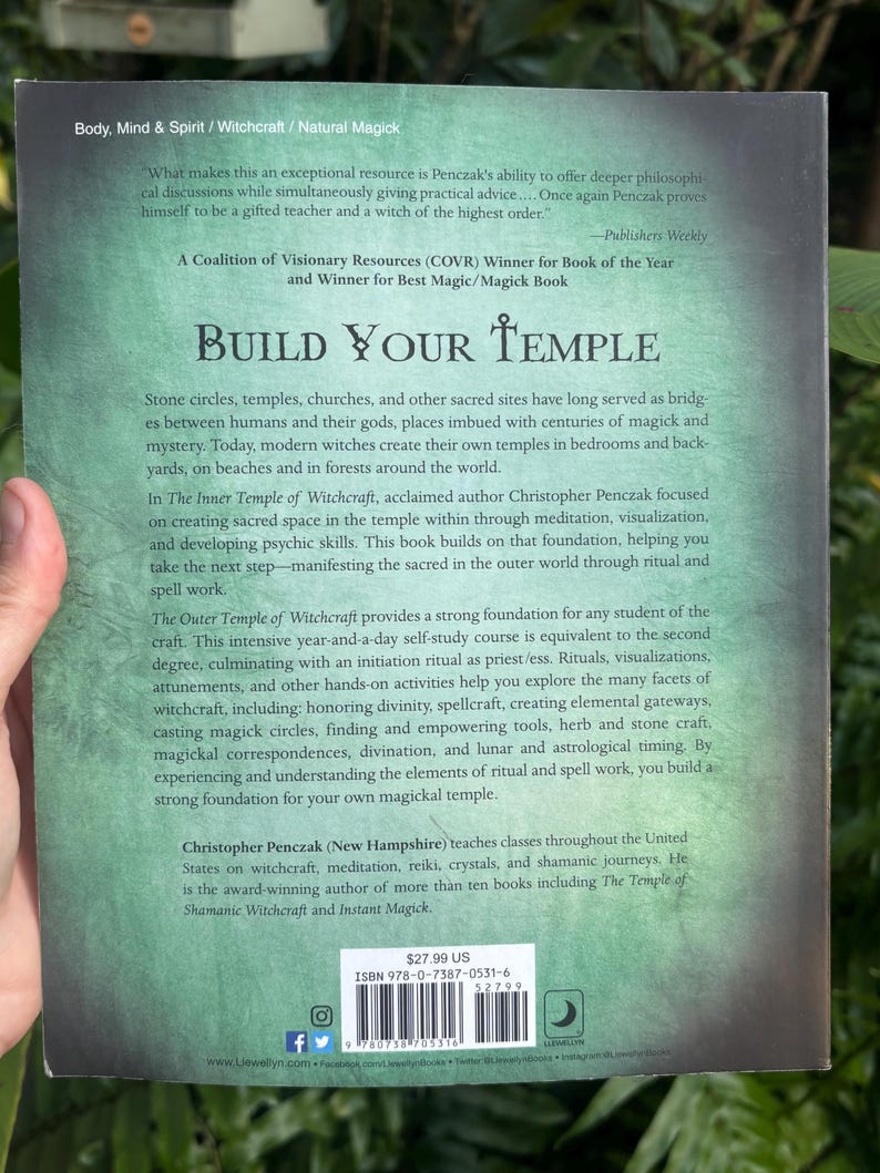 Pode incluir: Contra capa de um livro intitulado "Build Your Temple" de Christopher Penczak. O tema do livro &eacute; bruxaria e magia. A capa &eacute; um gradiente de verde e cinza com texto branco. O livro tem um c&oacute;digo de barras e o pre&ccedil;o &eacute; de $27,99.