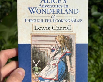 May include: A paperback book titled "Alice's Adventures in Wonderland & Through the Looking-Glass" by Lewis Carroll. The cover features an illustration of Alice and the White Rabbit, with text that reads "Signet Classic".