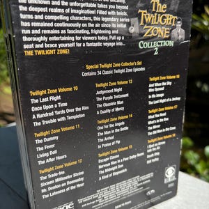 May include: A black DVD box set with a silver title, "The Twilight Zone Collection 2". The box features a photo of Rod Serling, the creator of the show, and a list of episodes included in the set.