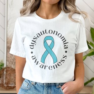 May include: White t-shirt with a teal ribbon and the text "dysautonomia awareness" in a circle around the ribbon.