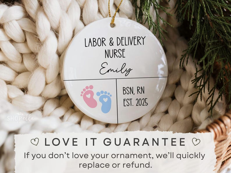 K&ouml;nnte beinhalten: Wei&szlig;er Keramikschmuck mit dem Text "LABOR & DELIVERY NURSE" und dem Namen "Emily". Er zeigt rosa und blaue Babyf&uuml;&szlig;e und den Text "BSN, RN EST. 2025". Der Schmuck h&auml;ngt an einem goldenen Faden.