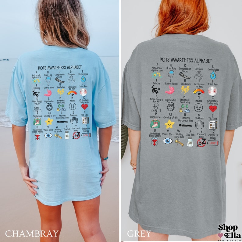 May include: Two oversized t-shirts, one light blue and one gray, each featuring the "POTS Awareness Alphabet." The shirts display an alphabet of POTS symptoms with colorful illustrations and text. The light blue shirt is labeled "Chambray," and the gray shirt is labeled "Grey."