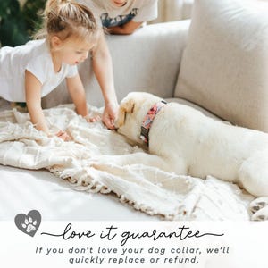 May include: A cream-colored Labrador Retriever wearing a floral dog collar with pink and red flowers. A child and an adult are interacting with the dog on a cream-colored blanket. The text "love it guarantee" is at the bottom.