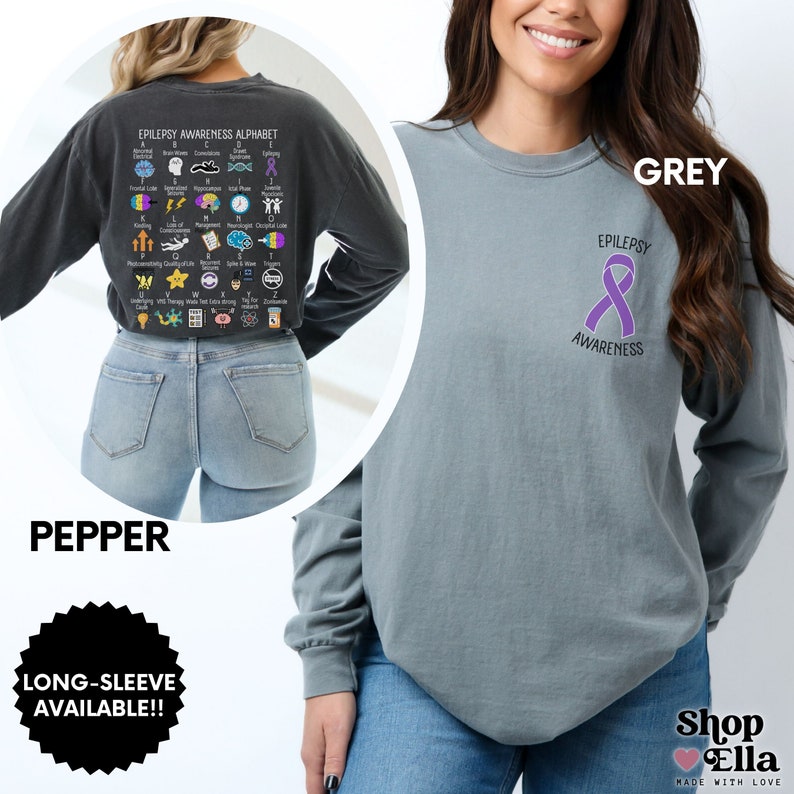 May include: A long-sleeved t-shirt in a grey color with the text "EPILEPSY AWARENESS" and a purple ribbon on the front. The back of the shirt features an alphabet chart with icons representing different aspects of epilepsy awareness. The shirt is available in a pepper color.