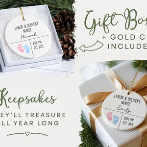 K&ouml;nnte beinhalten: Wei&szlig;er Keramikschmuck mit goldener Kordel, mit dem Text "Labor & Delivery Nurse" und einem Namen, sowie rosa und blaue Fu&szlig;abdr&uuml;cke. Der Schmuck befindet sich in einer Geschenkbox und auf einem verpackten Geschenk.