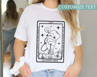 May include: White t-shirt with a black and white illustration of a hand holding a stethoscope with flowers and stars. The text "THE LAST CHAPTER IS THE MOST IMPORTANT" and "THE HOSPICE NURSE" are printed on the shirt. The text "LXIV" is also printed on the shirt. The text "CUSTOMIZE TEXT" is printed at the top of the image.