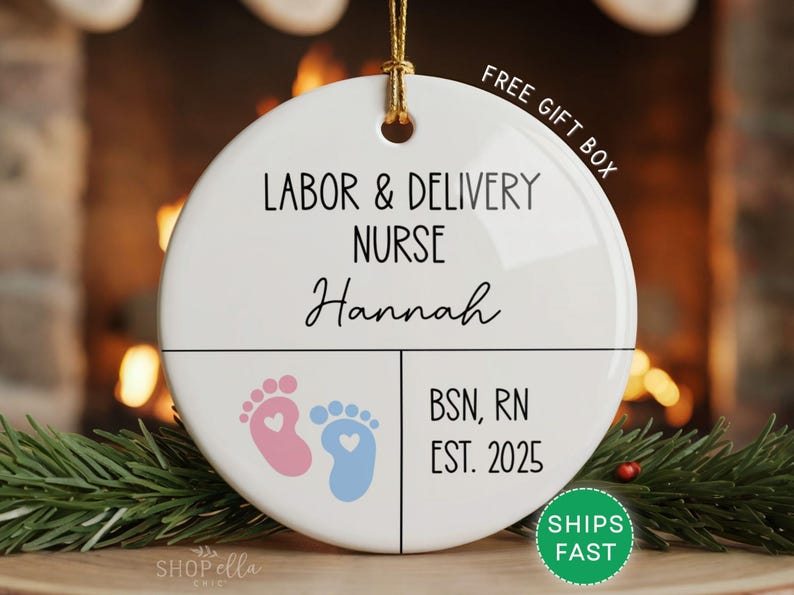 Round ceramic ornament with white background featuring pink and blue baby footprints. Text reads Labor and Delivery Nurse with custom name, credentials, and year. Includes Free Gift Box and Ships Fast.