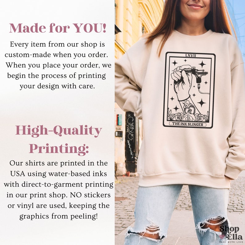 Puede incluir: Una sudadera beige con una ilustraci&oacute;n en blanco y negro de una mano sosteniendo una m&aacute;quina de tatuaje. La ilustraci&oacute;n est&aacute; rodeada por un borde negro y el texto "LXVII THE INK SLINGER".