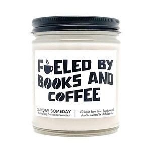 May include: A glass jar candle with a black lid. The label reads "FUELED BY BOOKS AND COFFEE" in black text. Below the text, it says "SUNDAY SOMEDAY natural soy & coconut candles" and "40-hour burn time, hand poured, double scented & phthalate-free."