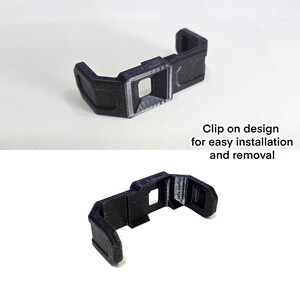 Pu&ograve; includere: Una clip nera a forma di U stampata in 3D con un'apertura quadrata centrale e bracci laterali angolati. Il testo "Clip on design for easy installation and removal" &egrave; stampato accanto all'oggetto, mostrato da due diverse angolazioni.