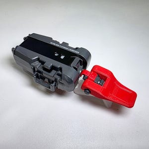 May include: A gray and red Beyblade X String Launcher. The launcher has a black panel with the text "Beyblade X String Launcher".