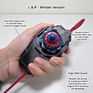 May include: A black and red Beyblade winder with a blue and red top. The winder has an extended sloped area for larger hands and a sloped surface for better grip. The text "L & R - Winder Version" is visible.
