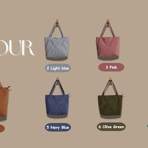 May include: A display of tote bags in various colors: brown, light blue, pink, cream, navy blue, olive green, and forest green. Each bag hangs from a wooden peg, with color labels below. The text "BAG COLOUR" is at the top.