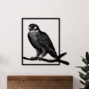 Puede incluir: Arte de pared de metal en blanco y negro con un halcón posado en una rama. El halcón está representado en un estilo realista con plumas detalladas y un pico afilado.