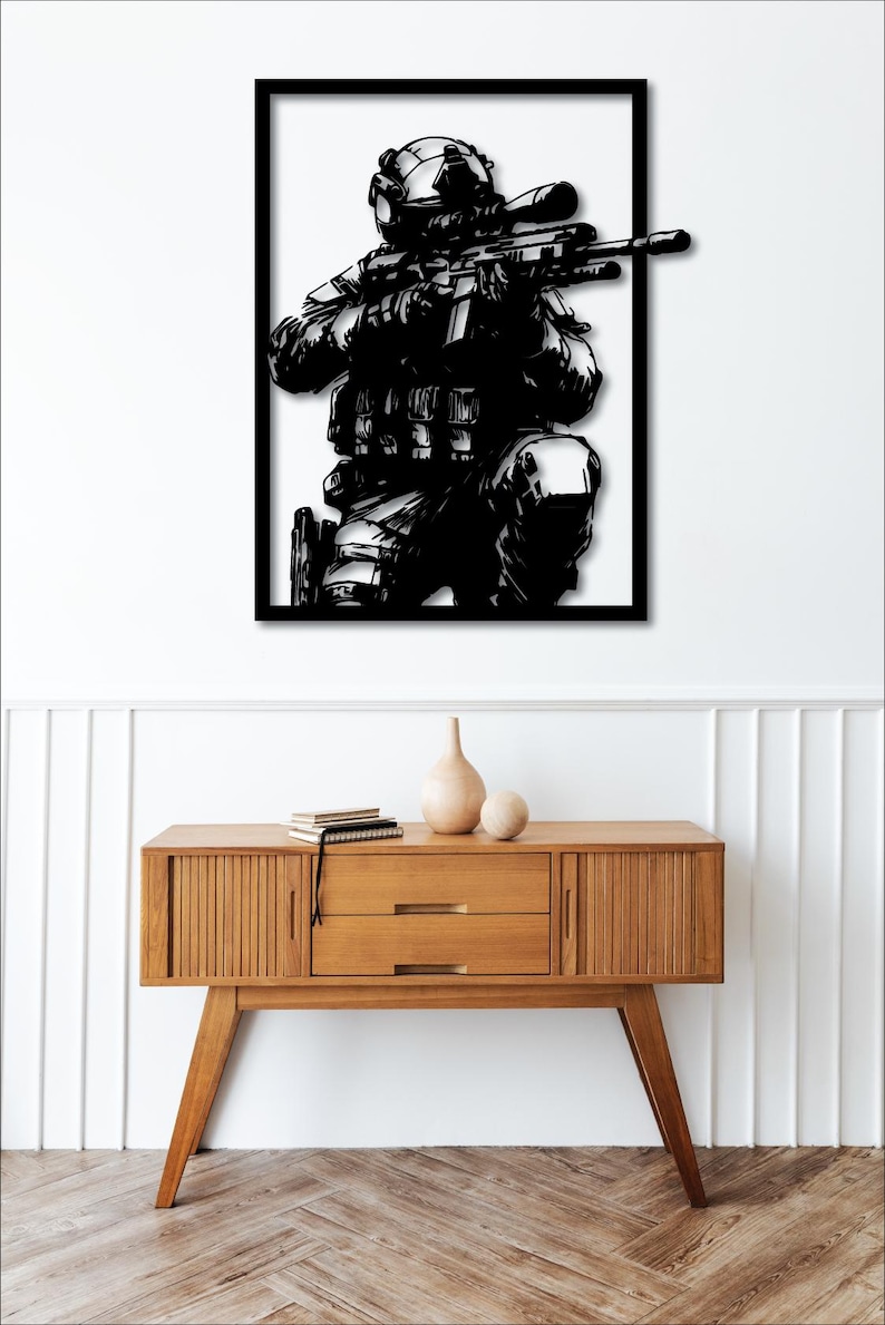 May include: Black and white silhouette of a soldier holding a rifle, framed in a black frame.