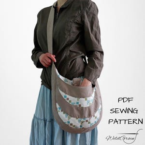 Op de afbeelding: Een beige schoudertas met een geometrisch patroon en een lange riem. De tas heeft een gebogen ontwerp met een zak aan de voorkant. De tekst "PDF SEWING PATTERN" en "WildGreen" zijn zichtbaar.