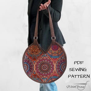 Op de afbeelding: Een ronde handtas met een kleurrijk mandala-patroon in tinten rood, blauw, oranje en teal. De tas heeft bruine handvatten en randen. De tekst "PDF SEWING PATTERN" en "WildGreen" zijn zichtbaar.