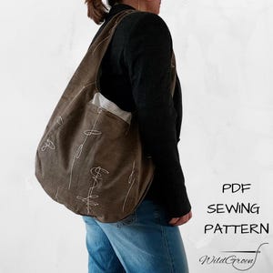 Op de afbeelding: Een bruine schoudertas met witte abstracte lijnkunst. De tas wordt over de schouder gedragen. De tekst "PDF SEWING PATTERN" en "WildGreen" zijn zichtbaar aan de rechterkant van de afbeelding.