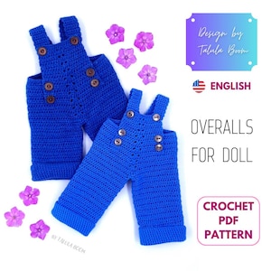 May include: Two pairs of bright blue crocheted doll overalls featuring dark brown buttons on the straps and sides. The text on the image reads Design by Talula Boom, ENGLISH, OVERALLS FOR DOLL, and CROCHET PDF PATTERN, accompanied by purple flowers.