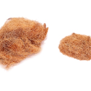 Könnte beinhalten: Zwei kupferfarbene Scheuerschwämme werden vor weißem Hintergrund gezeigt. Die Schwämme bestehen aus feinen, miteinander verwobenen Strängen, wobei ein Schwamm größer ist als der andere. Die Textur der Schwämme ist sichtbar, was darauf hindeutet, dass sie zum Reinigen bestimmt sind.