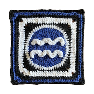 May include: Crocheted square with a blue and white wave design in the center, surrounded by black and white borders. The square is framed by a black border with a blue trim.