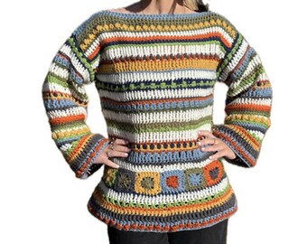 May include: A colourful striped crochet sweater with a geometric pattern at the bottom. The sweater has long sleeves and a wide neckline.