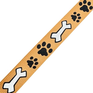 May include: A tan ribbon with black paw prints and white bone designs.