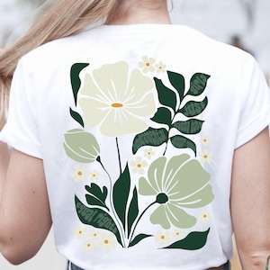 Könnte beinhalten: Weißes T-Shirt mit einem Blumendesign in Grün- und Cremetönen. Das Design umfasst große Blumen, Blätter und kleine gänseblümchenartige Blüten. Textelemente sind "equal rights", "girls just wanna have" und "fundamental".