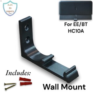 Op de afbeelding: Zwarte wandhouder voor EE/BT HC10A, met schroeven en pluggen. De houder heeft een gebogen ontwerp en is gemarkeerd met "Wall Mount" en "Includes:" met het merklogo "Alec 3D Prints".