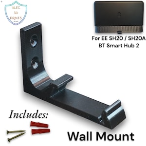 Op de afbeelding: Zwarte wandbevestiging voor EE SH20/SH20A BT Smart Hub 2, met schroeven en pluggen. De L-vormige houder heeft een platte basis en een opstaande rand. De tekst "Wall Mount" is zichtbaar.
