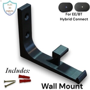 Op de afbeelding: Zwarte wandbevestiging met een gebogen ontwerp, met een kleine rechthoekige steun. De afbeelding bevat schroeven en pluggen. Tekst op de afbeelding luidt "For EE/BT Hybrid Connect" en "Wall Mount". Het logo "ALEC 3D PRINTS" is ook zichtbaar.