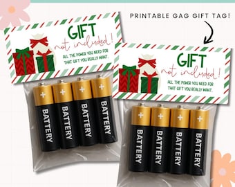 Puede incluir: Dos juegos de pilas empaquetados con una etiqueta de regalo imprimible. La etiqueta presenta un diseño festivo con cajas de regalo y el texto "GIFT not included!" y "ALL THE POWER YOU NEED FOR THAT GIFT YOU REALLY WANT."