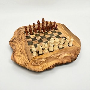 Puede incluir: Un juego de ajedrez de madera con un dise&ntilde;o de borde vivo. El tablero presenta un patr&oacute;n de tablero de ajedrez con cuadrados oscuros y claros. Las piezas de ajedrez son de color marr&oacute;n y crema, dispuestas en las posiciones iniciales. El tablero es de madera de olivo.