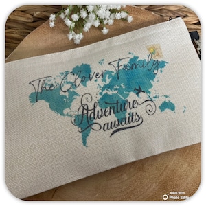 May include: A white canvas zippered pouch with a blue watercolor world map and the text "The Clover Family Adventure Awaits".