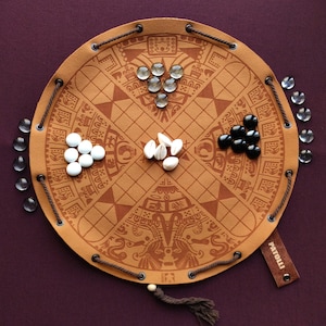 Juego de mesa maya antiguo de Patolli en estuche de piel sintética.