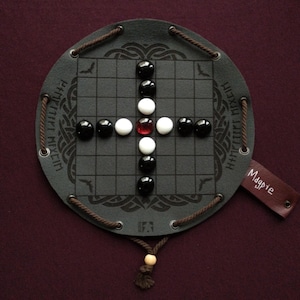 Ajedrez vikingo Hnefatafl Magpie: un antiguo juego de mesa en una funda de piel sintética.