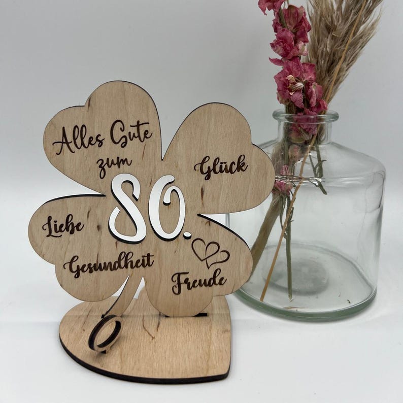 Holz-Kleeblatt als Geldgeschenk, wahlweise in 12,5 cm oder 18 cm Größe. Mit eingravierter Jahreszahl (z. B. 18, 30, 40, 50, 60, 66, 70, 80) oder individueller Wunschzahl. Perfekt als Glücksbringer zum Geburtstag, Jubiläum oder besonderen Anlässen. Geldscheine können dekorativ befestigt werden