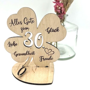 Holz-Kleeblatt als Geldgeschenk, wahlweise in 12,5 cm oder 18 cm Größe. Mit eingravierter Jahreszahl (z. B. 18, 30, 40, 50, 60, 66, 70, 80) oder individueller Wunschzahl. Perfekt als Glücksbringer zum Geburtstag, Jubiläum oder besonderen Anlässen. Geldscheine können dekorativ befestigt werden