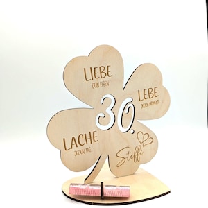 Może przedstawiać: Drewniany znak w kształcie koniczyny z liczbą 30 w środku i napisami "Liebe dein Leben", "Liebe jeden Moment", "Lache jeden Tag" i "Steffi" wok&oacute;ł.