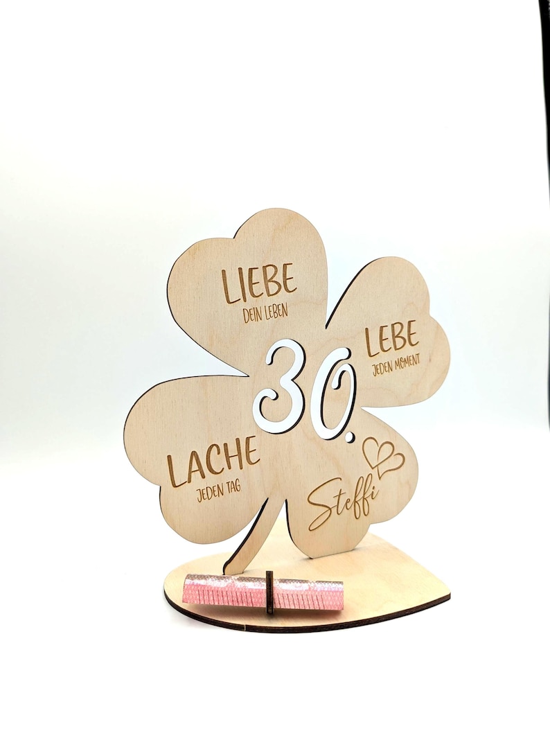 Może przedstawiać: Drewniany znak w kształcie koniczyny z liczbą 30 w środku i napisami "Liebe dein Leben", "Liebe jeden Moment", "Lache jeden Tag" i "Steffi" wok&oacute;ł.
