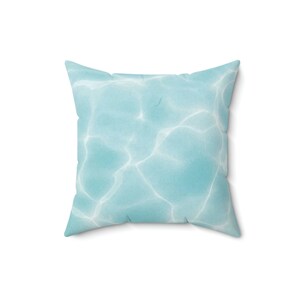 May include: A light blue throw pillow with a pattern of water ripples.