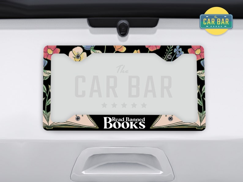 May include: A black license plate frame with a floral design and the text "The Car Bar" and "Read Banned Books".