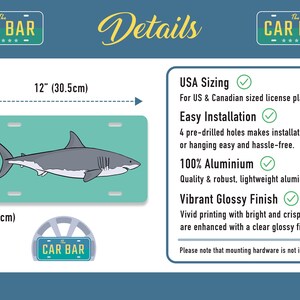 May include: A white great white shark graphic on a turquoise license plate. The license plate is 12 inches by 6 inches and made of aluminum. The text "The Car Bar" is on the top of the license plate.